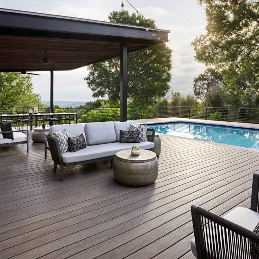 Grey decking with outdoor sofas beside a pool